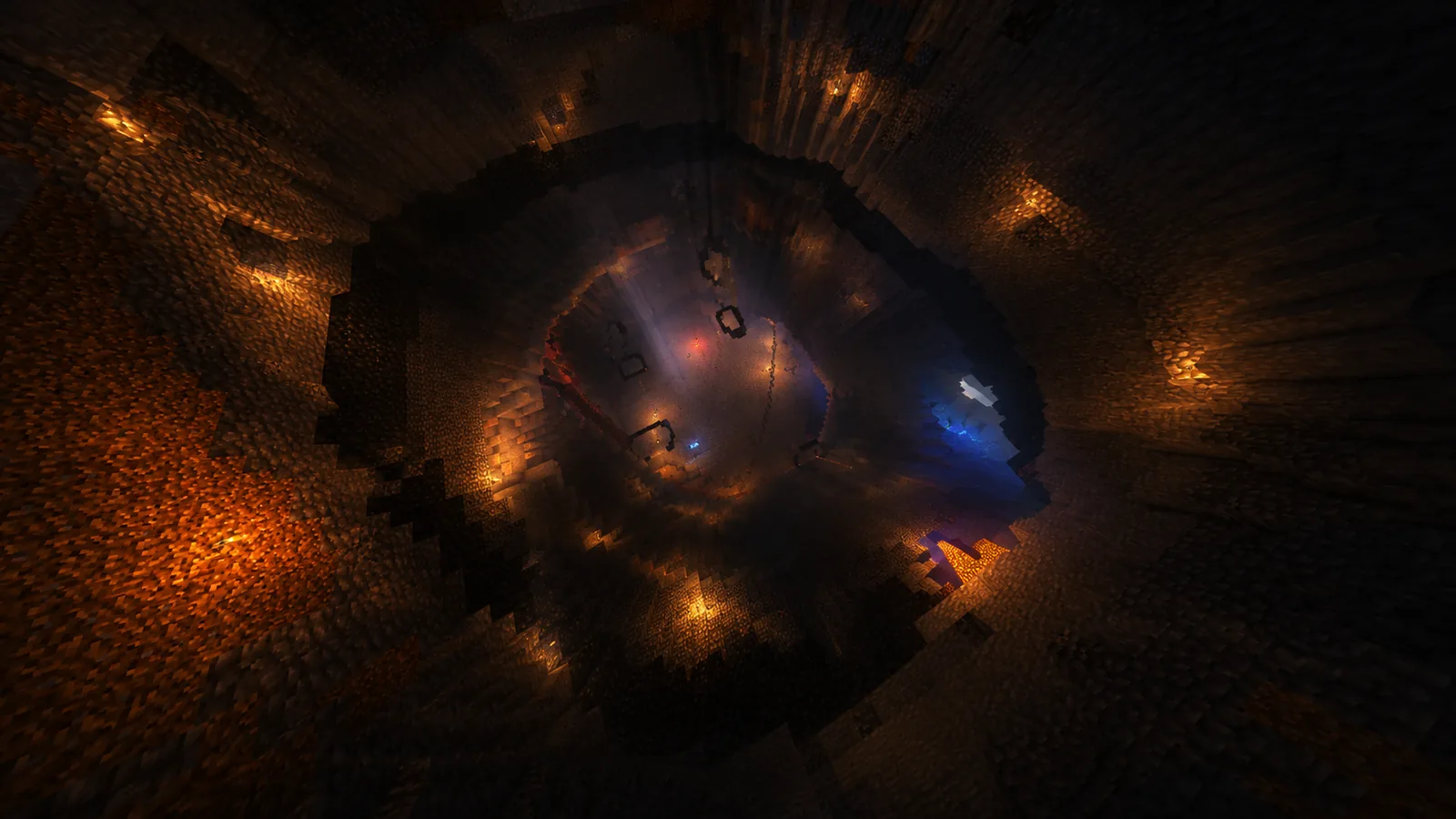 A wide hollow carved out under the badlands, lit by scattered lanterns and a cold blue glow
